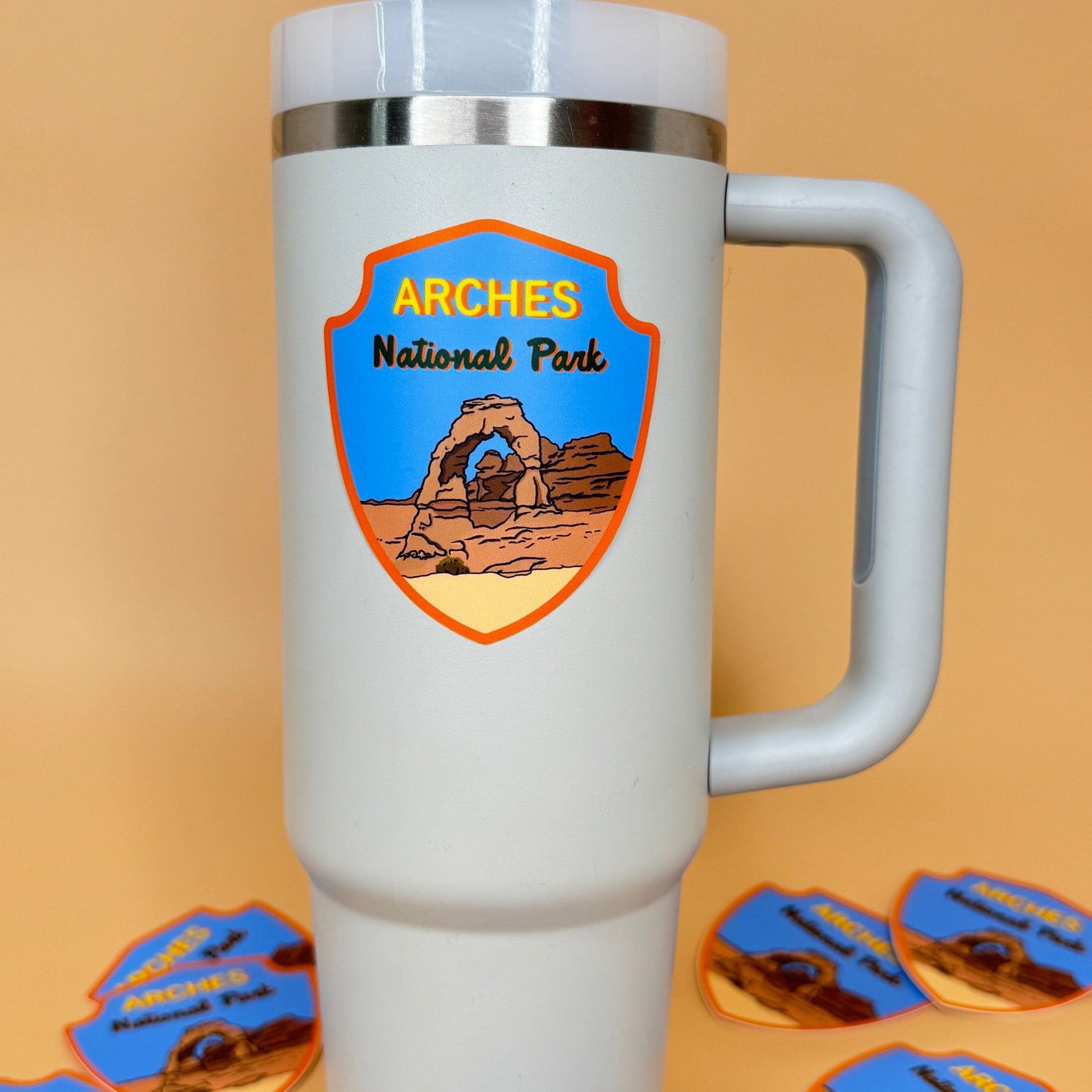 Grey tumbler with Arches National Park Sticker on a beige background